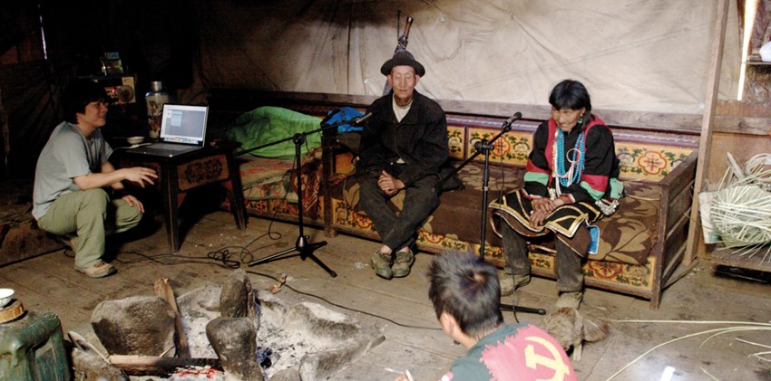 Hou Dudu recording the Lhoba in Milin County, Nyingchi, Tibet. The man in national costume (right) is Da Yaxia, the only singer left in the Lhoba area, aged 90 at the time of recording. He has since died.